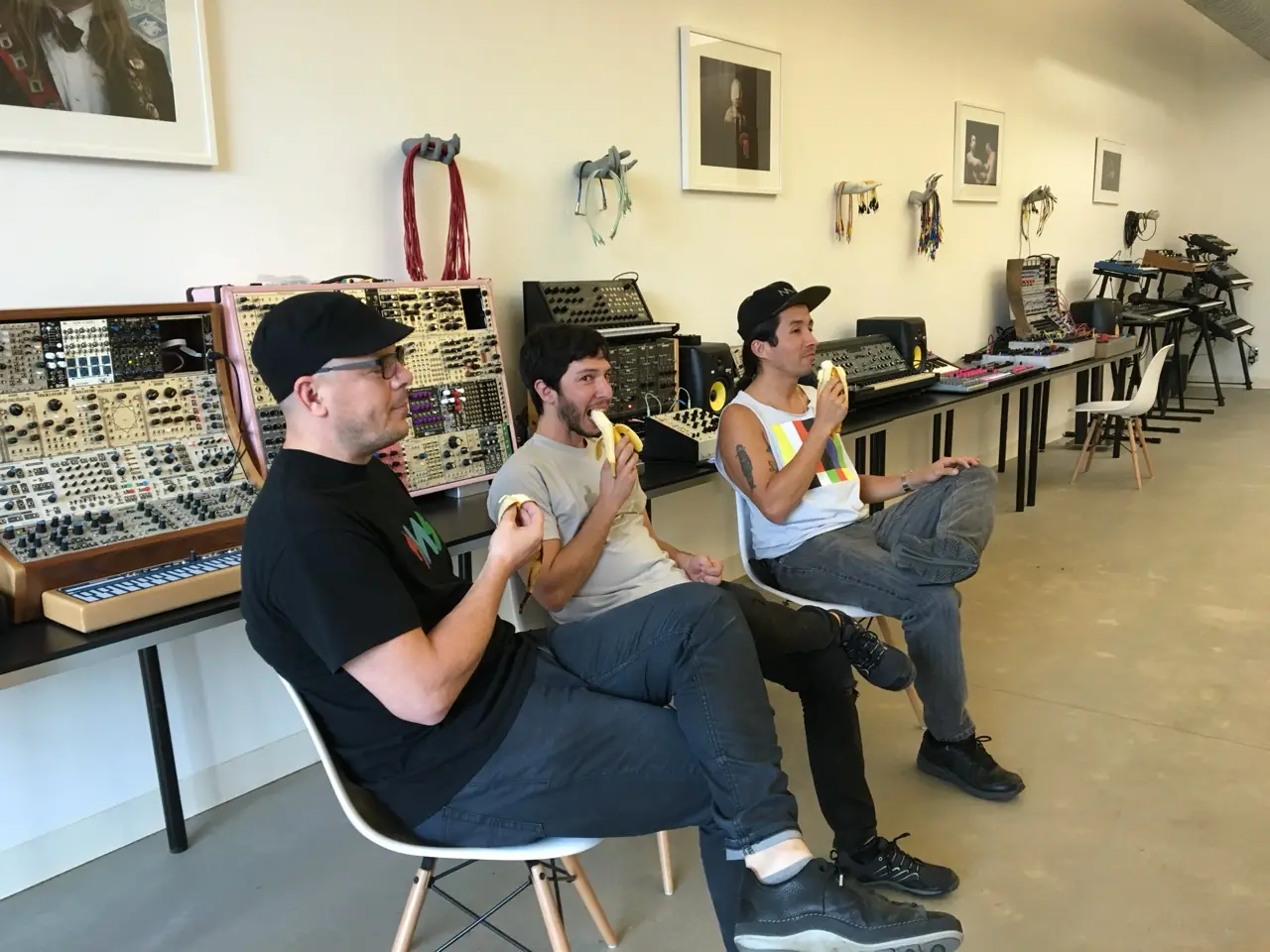 Banana break at the Muffwiggler Store, Portland: three men eating bananas in a gallery of modular synths