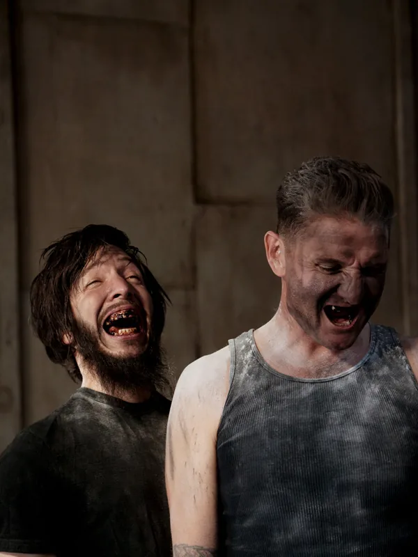 Cyrusrex and Douglas J. McCarthy laughing, their faces and clothes dusted grey