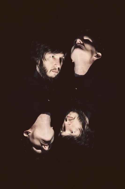 Cyrusrex and Douglas J. McCarthy in the dark, the picture mirrored upside down beneath them