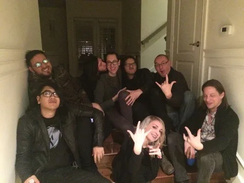 Moe, Surachai, Cyrus, Justin, Steve, Richard Devine and others crowded on a staircase, a few of them throwing horns