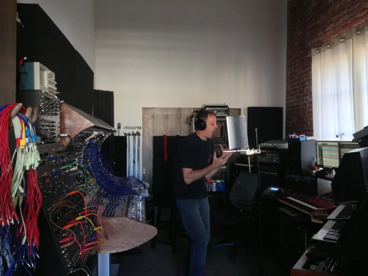 Tony Hawk in headphones in the Los Angeles studio, modular cases along the wall