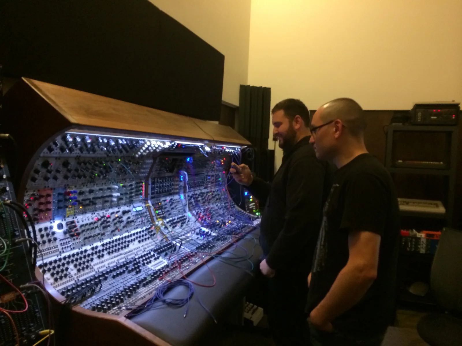 Moe and Richard Devine standing at the curved modular console, its panels lit