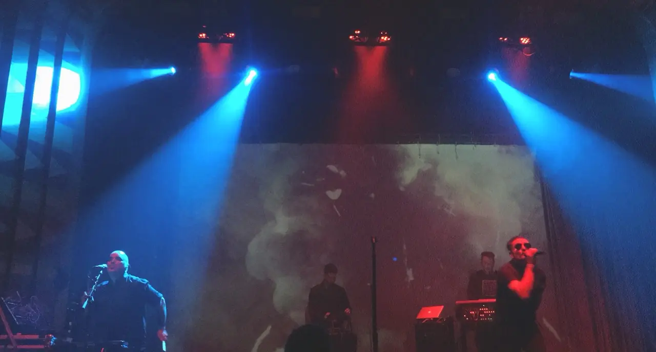 Black Line live at the Regent: two singers under blue spotlights, smoke projected behind