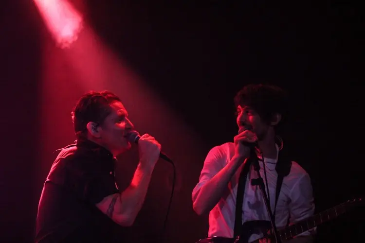 Douglas J. McCarthy and Zack Meyers singing on a red-lit stage at the Teragram Ballroom