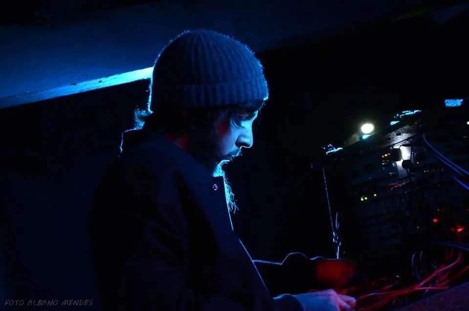 Cyrus in a beanie at his rig in blue light, DJMREX live in São Paulo with Douglas J. McCarthy