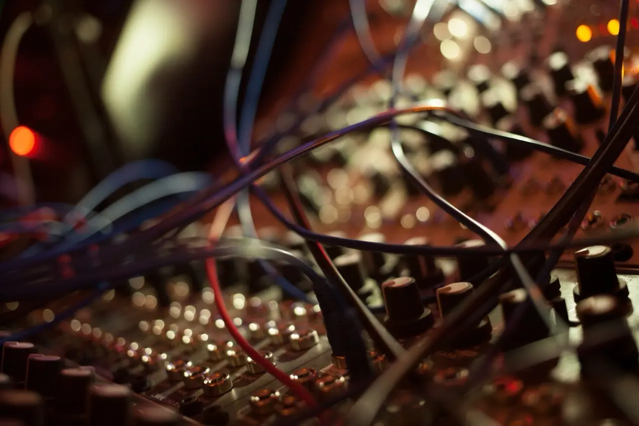 Close-up of a densely patched modular synth in warm light