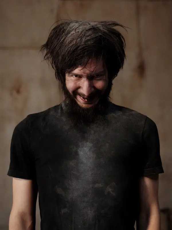 Portrait of a man with tousled dark hair, grinning