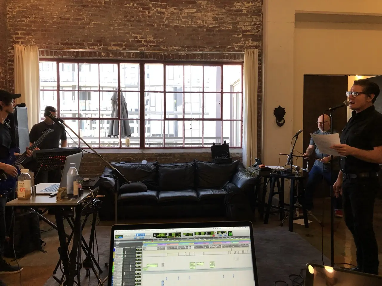 Black Line rehearsing in a brick loft in Los Angeles, a laptop running the session in the foreground
