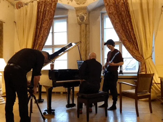 Black Line rehearsals at the Bonerowski hotel in Kraków: a grand piano by tall curtained windows, a guitarist, a camera on a tripod