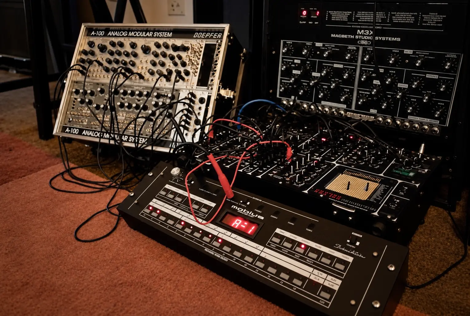 Modular and analogue synthesizers set up on a brown carpet