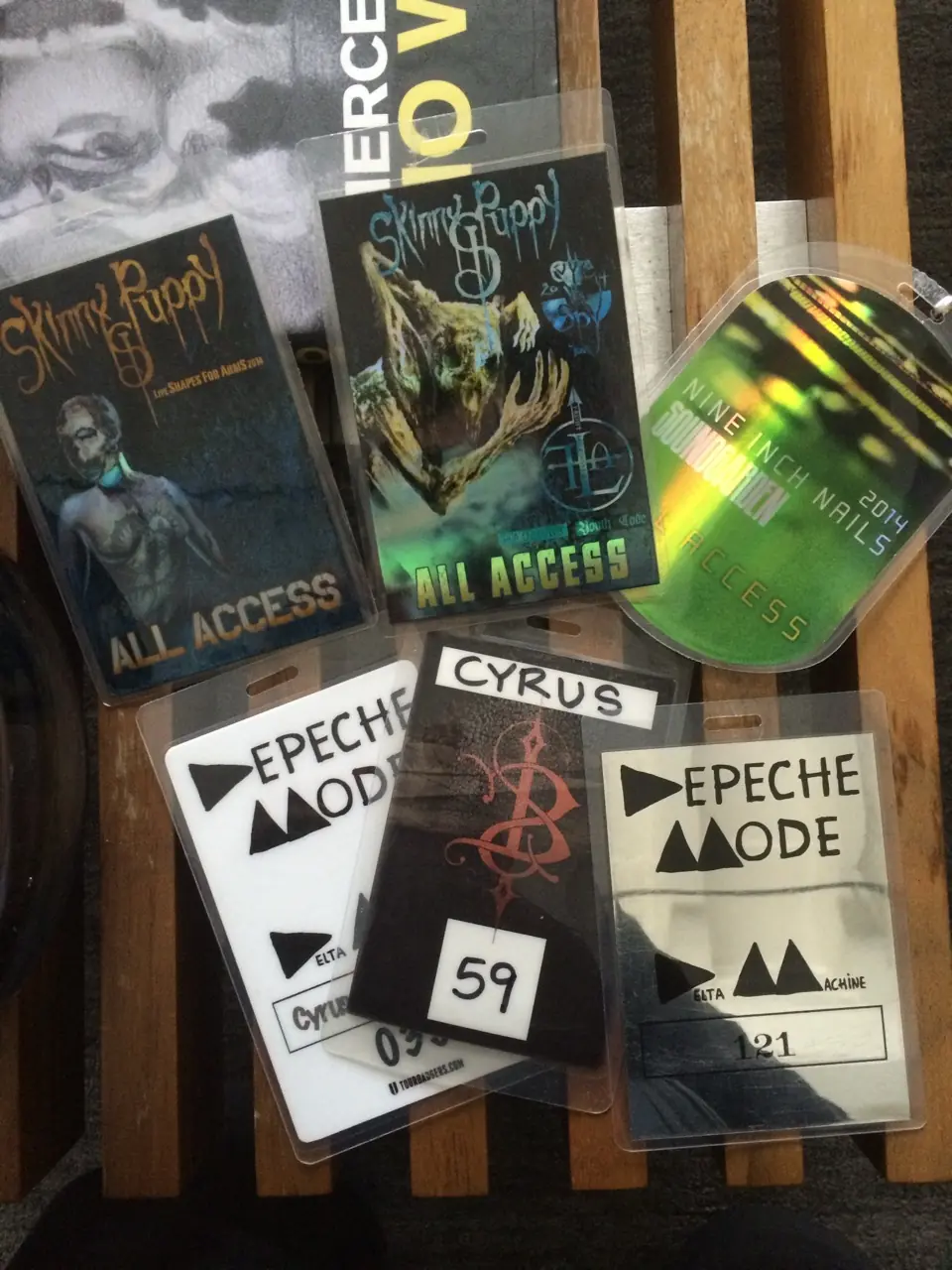 A spread of tour passes: Skinny Puppy all-access laminates, Depeche Mode Delta Machine passes, a Nine Inch Nails 2014 pass and one marked Cyrus