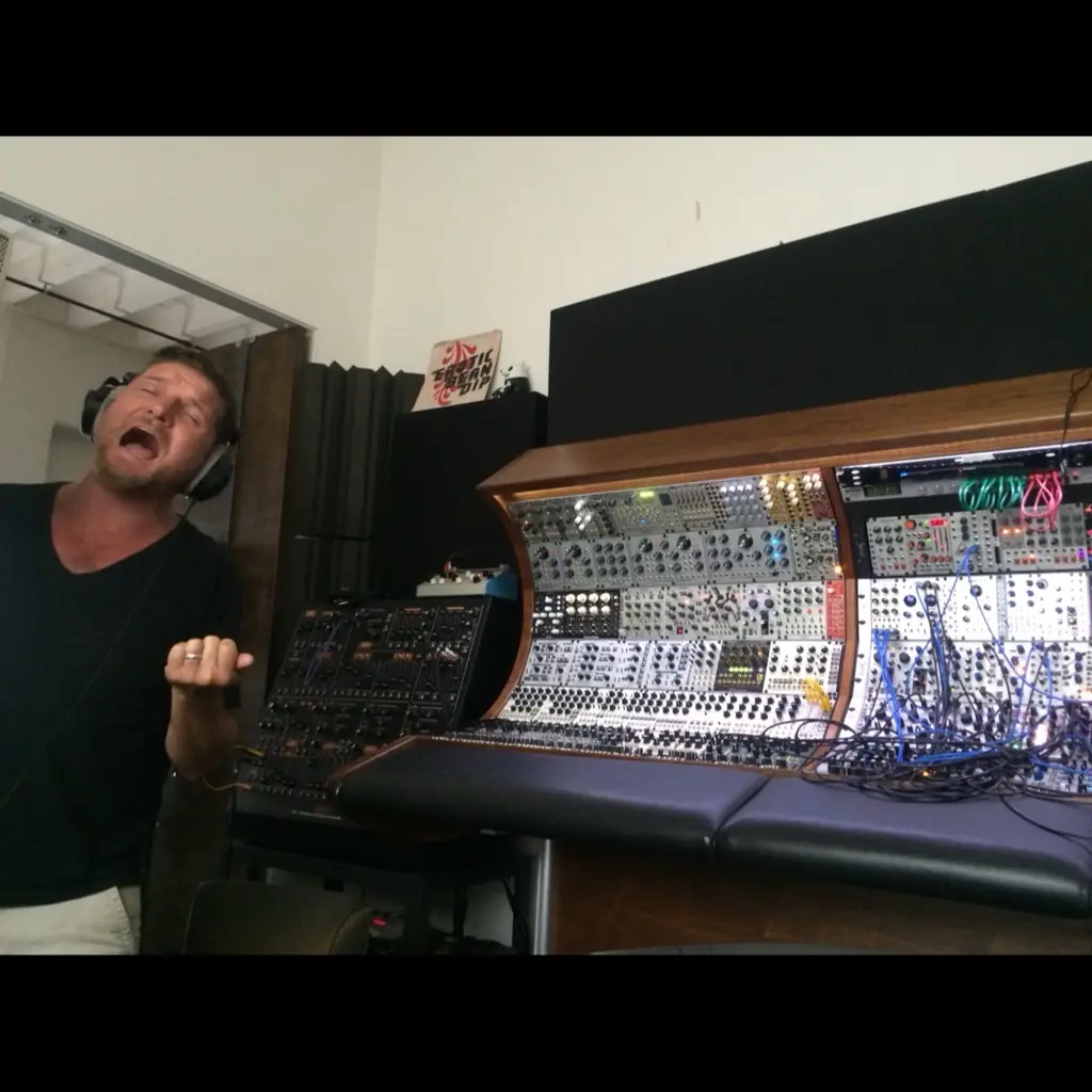 Douglas J. McCarthy singing a vocal take in headphones beside the modular, DJMREX sessions
